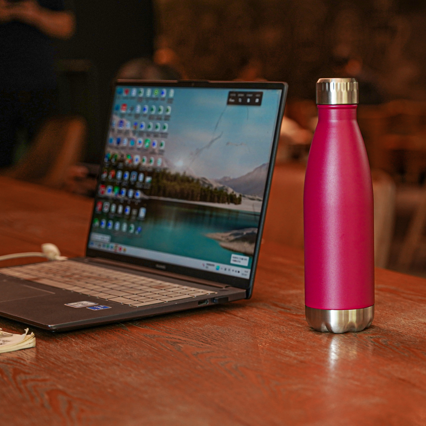 Leak proof stainless steel water bottle sitting next to laptop on office desk